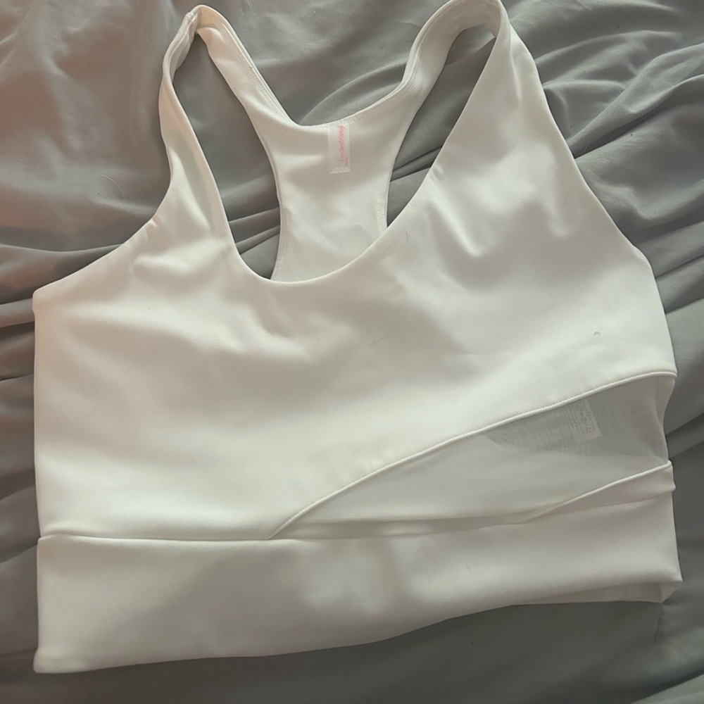 this is a free people tank top that is white with mesh cutouts